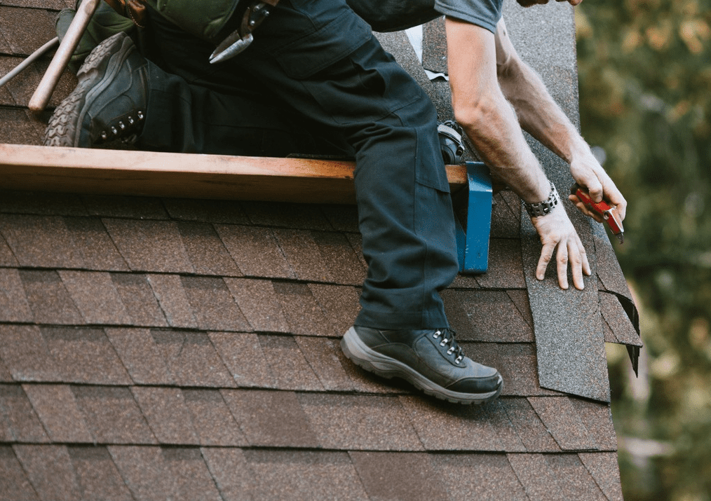 A man is working on the roof of his house.