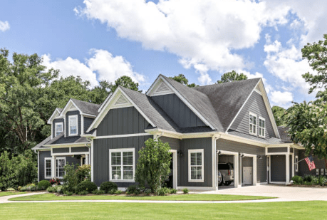 A large gray house with white trim and green grass.